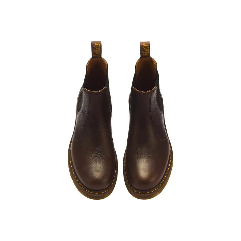 Dunkelbraune Chelsea Boots aus Leder mit gelben Ziernähten und hellbraunen Gummisohlen, Modell Dr. Martens Classic 2976.