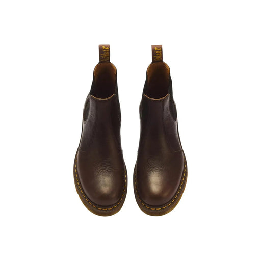 Dunkelbraune Chelsea Boots aus Leder mit gelben Ziernähten und hellbraunen Gummisohlen, Modell Dr. Martens Classic 2976.