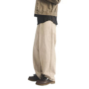 Beige Jeans mit weitem Bein, lockerer Passform und sichtbaren Nähten, kombiniert mit braunen Dr. Martens Herren-Ledermokassins von Adrian