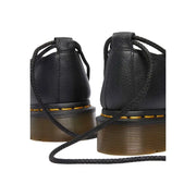 Black leather slip on shoes for women by dr martens shown from the back side highlighting the heel design
