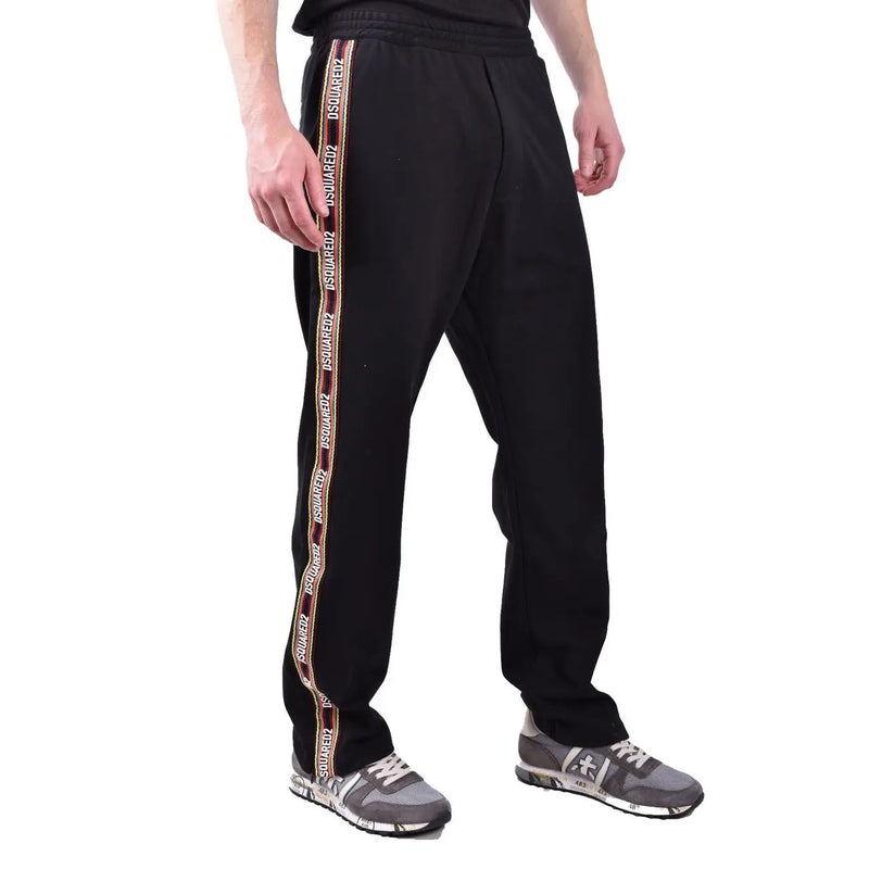 Dsquared men black cotton blend track pants with bold vertical white and maroon stripe featuring repeating logo