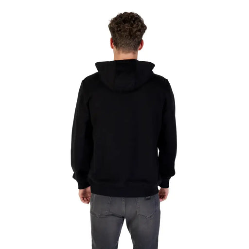 Men’s black cotton hooded sweatshirt with front pockets paired with dark grey jeans
