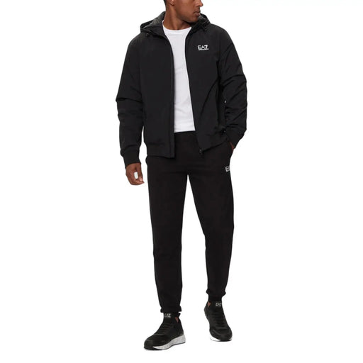 Ea7 Schwarze Herren-Steppjacke mit Kapuze und passendem Trainingsanzug mit dezentem weißen Logo auf Brust und Oberschenkel