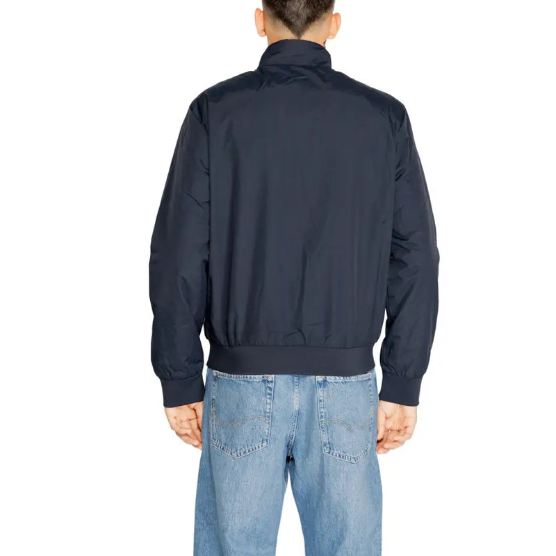 Men’s dark blue bomber jacket with stand-up collar and ribbed cuffs paired with light wash jeans