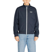 Men’s navy blue zip-up track jacket with white zipper and light blue jeans