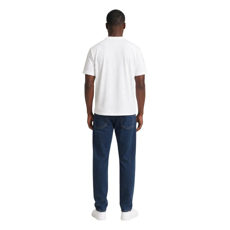 Ein Mann trägt ein weißes ea7 Herren-Baumwoll-T-Shirt in klassischer Passform und dunkelblaue Jeans.