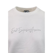 Weißes EA7 Emporio Armani Sweatshirt mit funkelndem Strasslogo auf der Brust, kombiniert mit einem grauen Baumwoll-Jumpsuit