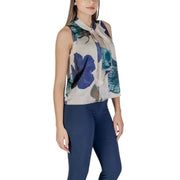 Floral sleeveless green blouse paired with navy pants in a stylish ensemble