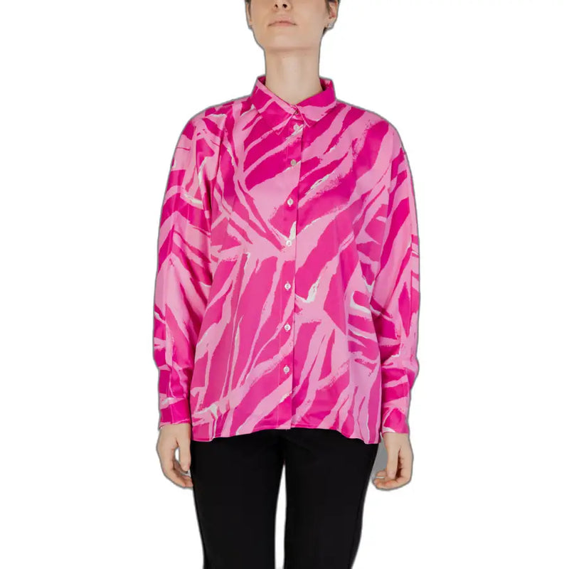 A fuchsia women’s long button-down shirt with pink and white zebra stripes and a sleek satin-like finish for spring and summer