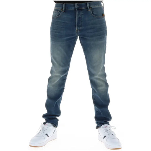Rückseite der G-Star Herrenjeans 51001 aus dunkelblauem Slim-Fit-Denim mit Knopfleiste, Baumwollstretch und braunem Markenpatch.