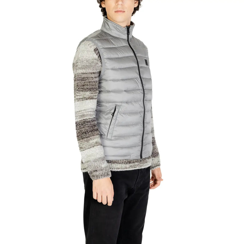Gianni lupo grey polyamide sleeveless gilet with zip featuring quilted design black zipper and chest logo patch worn over striped knit sweater