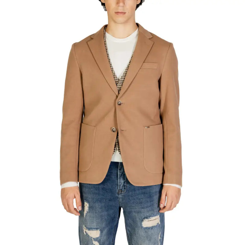 Gianni Lupo Beigefarbener Herrenblazer aus Baumwolle mit zwei Knöpfen vorne und aufgesetzten Taschen, getragen über einem weißen T-Shirt und einer gemusterten Weste.