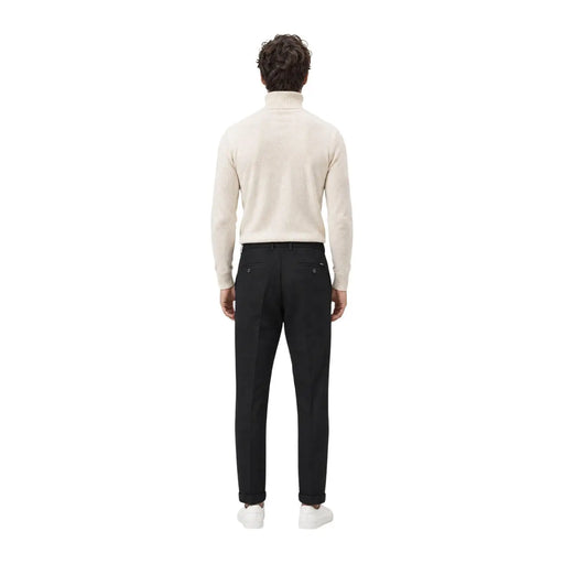 Ein Mann, der gianni lupo Schwarze Herren-Freizeithose aus Polyester, kombiniert mit einem cremefarbenen Rollkragenpullover