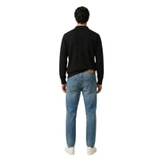 Eine mittelblaue Jeans mit braunem Leder-Markenaufnäher am hinteren Bund von gianni lupo
