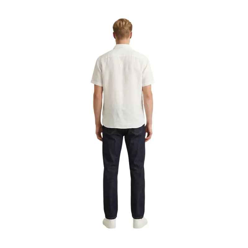 Ein Mann, der einen Gianni Lupo Weißes, kurzärmeliges Herrenhemd aus Baumwolle mit dunkelblauer Jeans