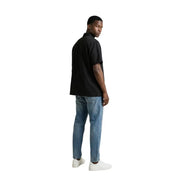 Gianni Lupo Schwarzes, kurzärmeliges Herrenhemd mit Knöpfen, kombiniert mit blauen Jeans und weißen Sneakers für einen lässigen Look