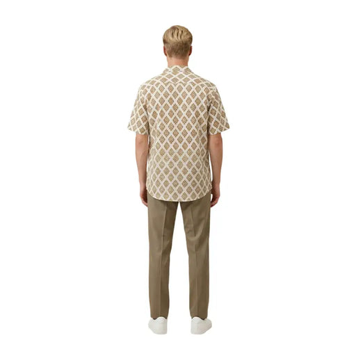 Ein Mann in Beige Gianni Lupo Herrenhemd mit sich wiederholendem braun-cremefarbenem geometrischem Muster und kurzen Ärmeln