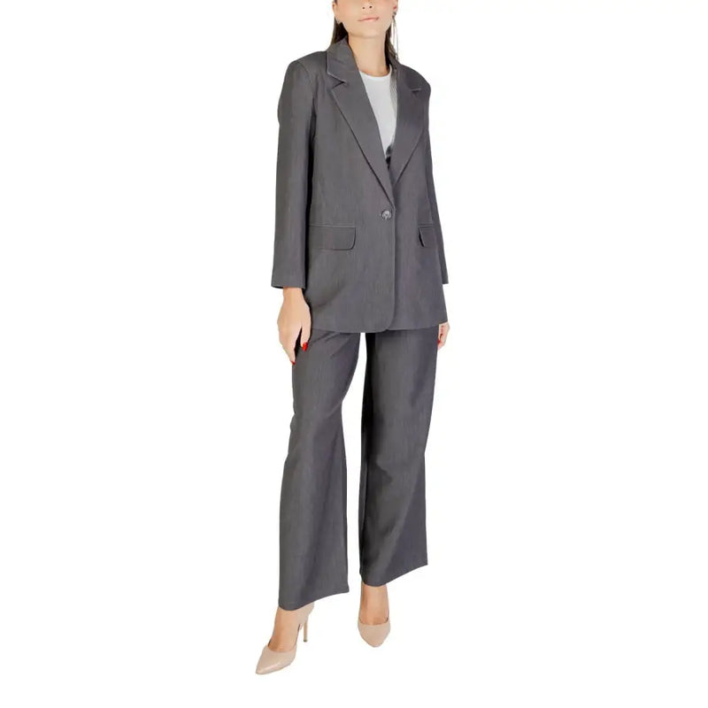 Women wearing a dark grey two-piece suit with a single-button blazer and wide-leg trousers