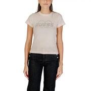 Woman wearing light pink Guess T-shirt with heart design and dark denim pants