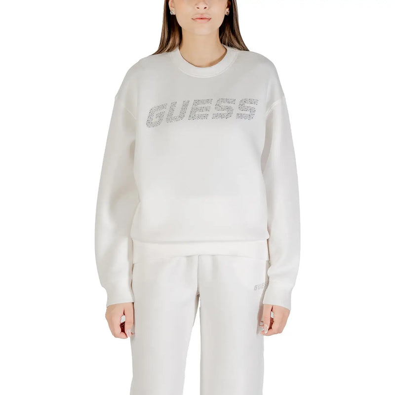 Woman wearing a long-sleeved white sweatshirt with rhinestone GUESS logo on chest