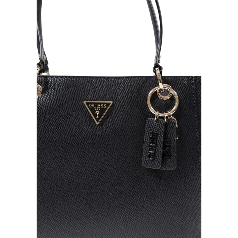 Black guess tote bag with textured polyurethane surface and gold-tone triangular logo featuring zip pockets