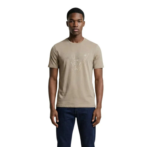 Beige Kurzarm Guess Männer t-shirt mit einem dezenten, metallisch-goldenen geometrischen Logodruck auf der Vorderseite