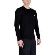 Guess Schwarzer Herren-Langarmpullover mit Rundhalsausschnitt und kleinem, pinkfarbenem Dreieckslogo auf der linken Brustseite.