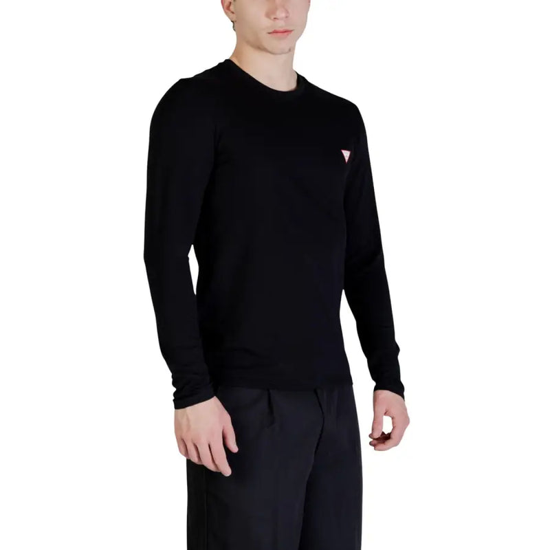 Guess Schwarzer Herren-Langarmpullover mit Rundhalsausschnitt und kleinem, pinkfarbenem Dreieckslogo auf der linken Brustseite.