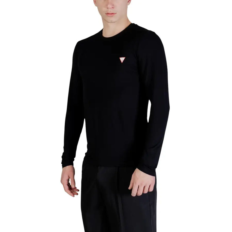 Guess Männer t-shirt Schwarzer, langärmeliger Rundhalspullover mit kleinem, pinkfarbenem Dreieckslogo auf der linken Brust.