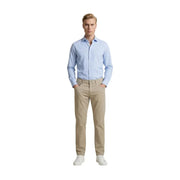 Ein Mann in Beige Guess Schmal geschnittene Baumwollmischhose kombiniert mit einem hellblauen Button-Down-Hemd