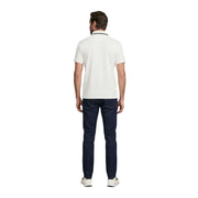 Ein Mann, der einen Guess Weißes Herren-Poloshirt mit kurzen Ärmeln aus Baumwollmischgewebe und marineblauem Besatz, dazu dunkle Jeans