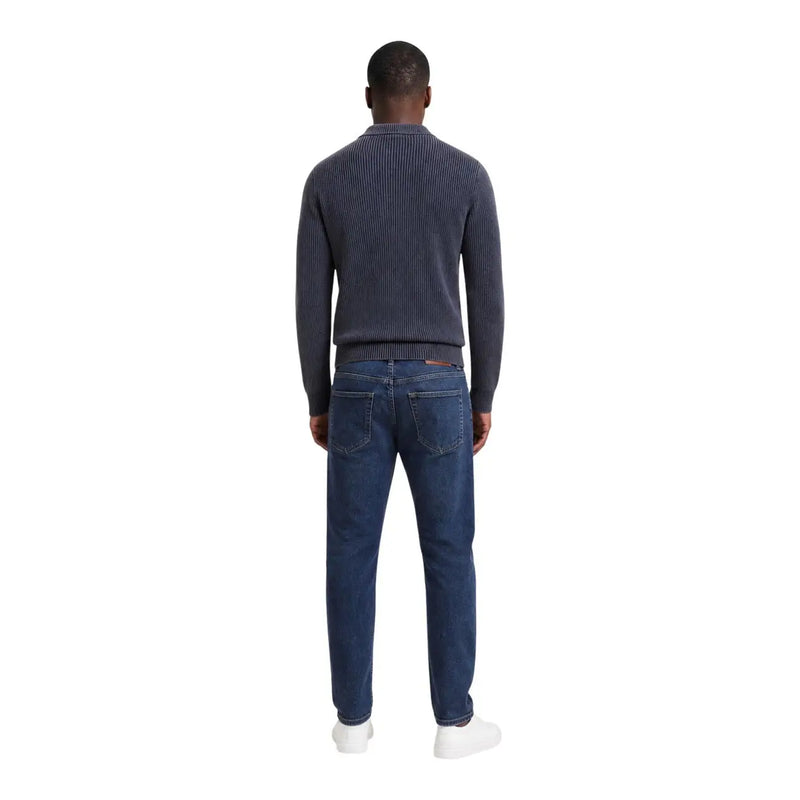 Guess Pullover „Manny“ für Herren aus dunkelblauem Rippstrick, getragen mit schmal geschnittenen Jeans, Vorderansicht