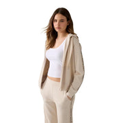 Guess women beige zip hoodie sweatshirt modal blend with black vertical lettering on sleeves and pants visible from the back