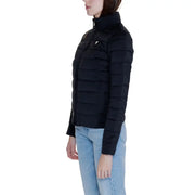 Black padded Guess Women jacket with high collar and front pockets worn with light blue jeans