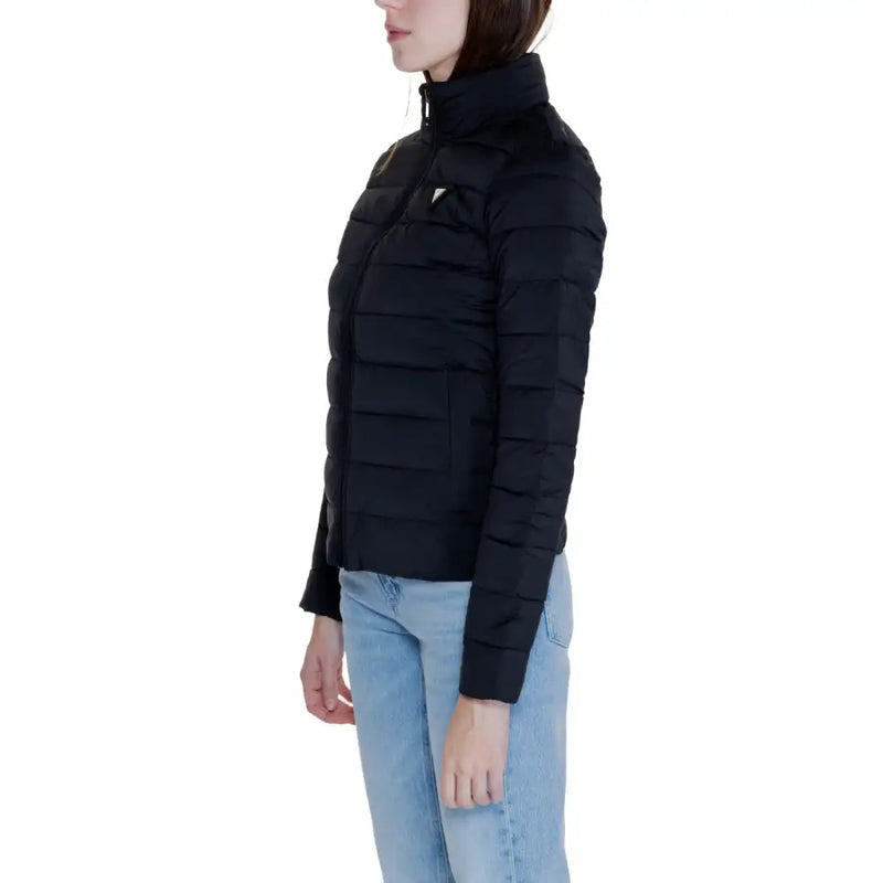 Black padded Guess Women jacket with high collar and front pockets worn with light blue jeans