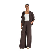 A woman wears a brown Guess women zip sweatshirt modal blend with a matching wide-leg pants set and subtle logo details