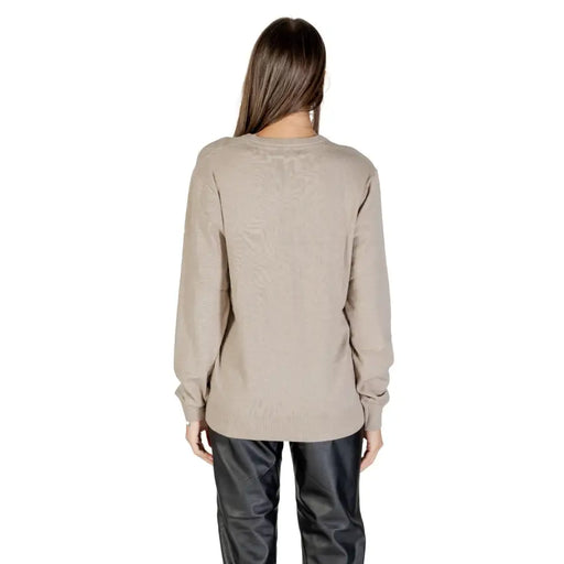 Guess Women Fall Winter beige crew-neck knit sweater paired with black leather-look trousers