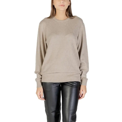 Woman wearing Guess Women Fall Winter beige round neck knit sweater and black leather pants
