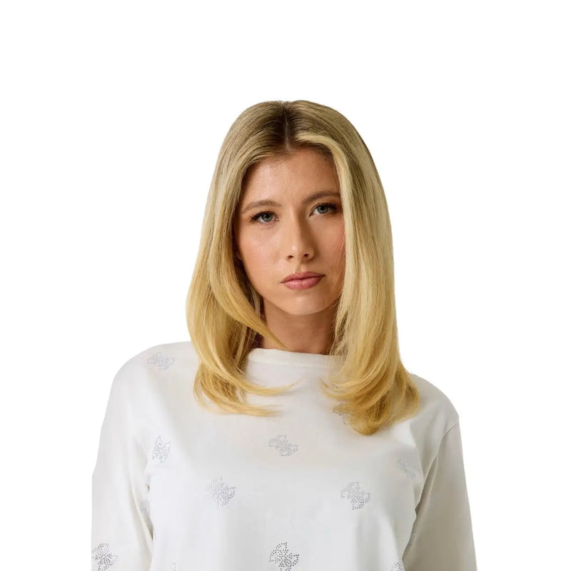 A woman with long blonde hair wearing a Guess women white cotton rhinestone Silvy T shirt with round neck
