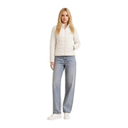 Eine Frau trägt eine guess Weiße, schwere Damen-Rollkragenjacke aus gestepptem Polyester mit Reißverschluss vorne und dezentem Logo