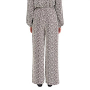 A woman wearing ichi women brown print trousers with a black and white patterned jumpsuit from fall winter collection