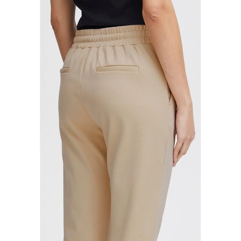 Beige hochtailliert ichi Damenhose mit elastischem Bund, vorderen Spitzentaschen und zwei Gesäßtaschen, von hinten gesehen.