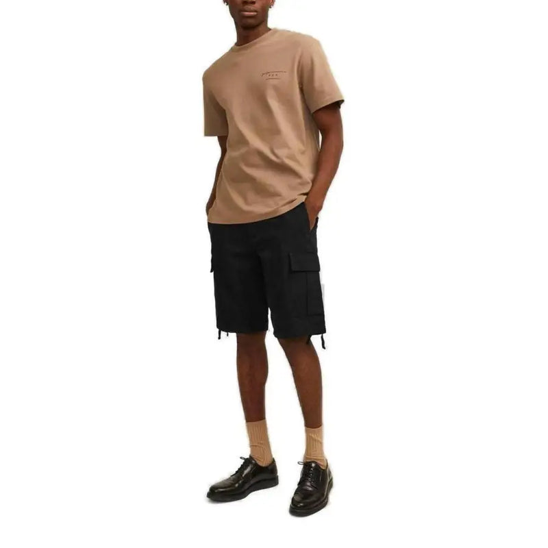 Beigefarbenes, kurzärmeliges Baumwollhemd t-shirt mit kleinem, gesticktem Logo, kombiniert mit schwarzen Jack & Jones Herren-Shorts aus Baumwolle mit Taschen