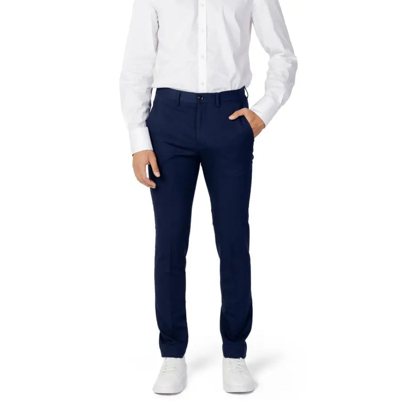 Men’s navy blue slim-fit dress pants with white button-up shirt and white sneakers