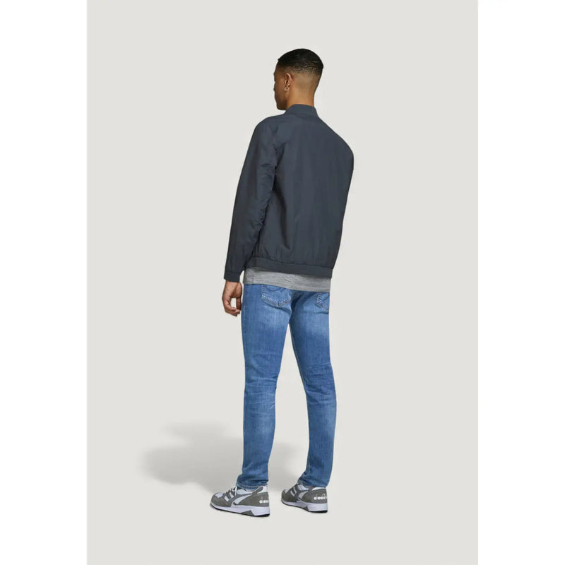 Dark gray bomber jacket with ribbed collar and cuffs worn over gray crew neck tee paired with Jack & Jones blue worn out jeans