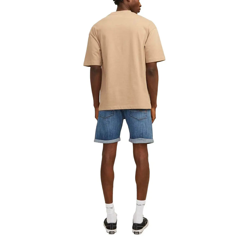 Beige oversized short-sleeved t-shirt with relaxed fit paired with jack & jones men’s blue shorts with pockets