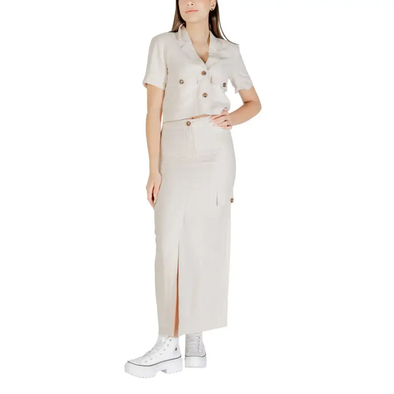A beige double-breasted short-sleeved shirt with buttoned pockets paired with a jacqueline de yong grey viscose midi skirt with side slits