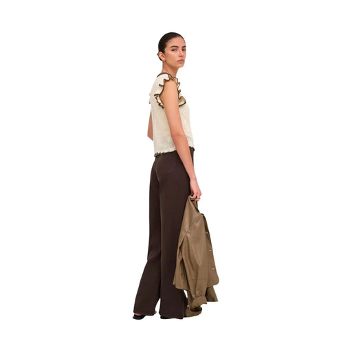 The model wears a jacqueline de yong beige sleeveless knit top with ruffled detailing in cotton fabric