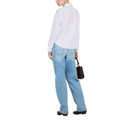 Black leather minimalist mini tote bag with structured rectangular shape and top handle paired with jacqueline de yong shirt