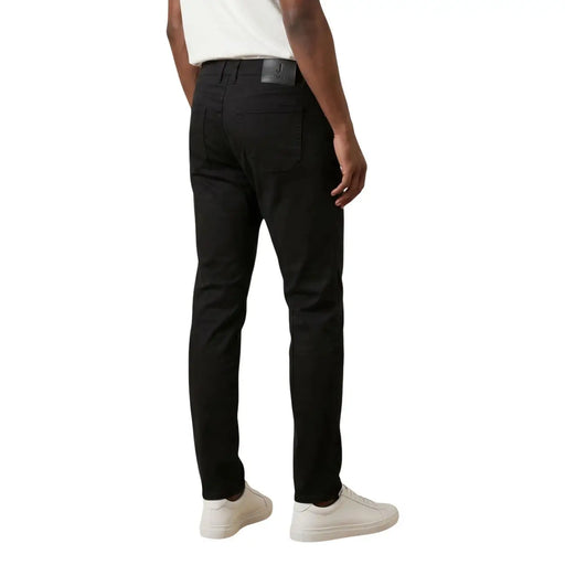 Black slim-fit chinos by Jeckerson featuring sleek tailored design and subtle stitching details for men